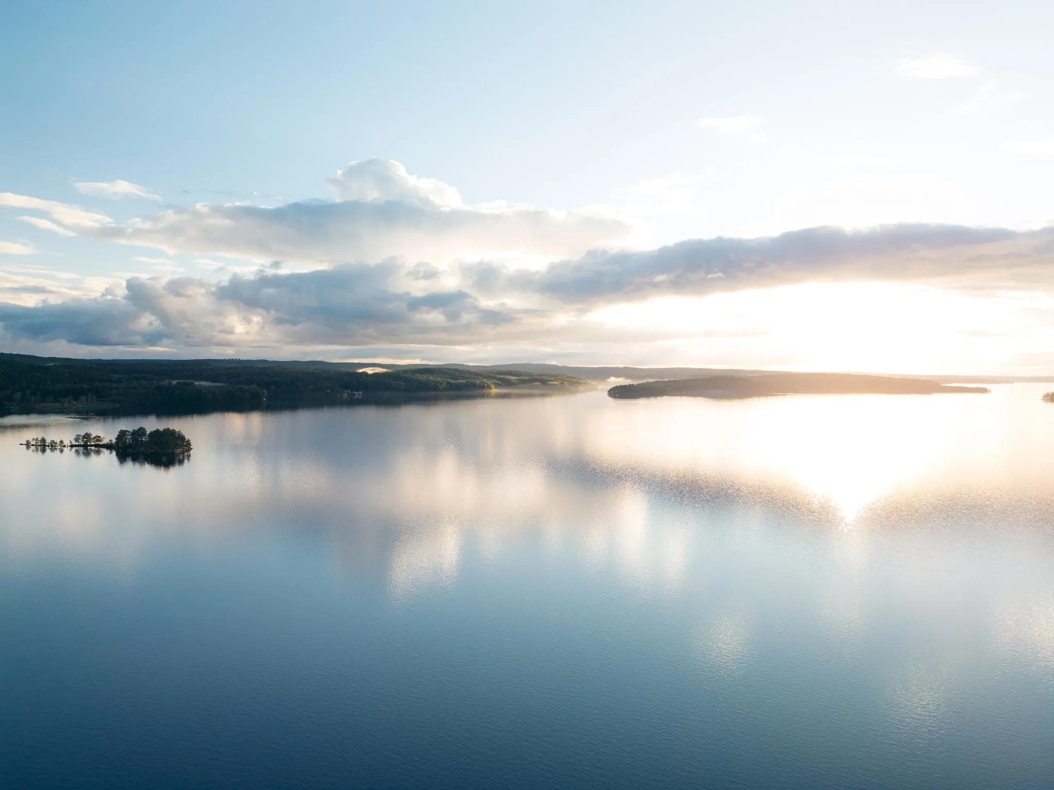 Aerial view of a wide lake with small islands at sunset
